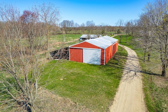view of pole building featuring a lawn and dirt driveway