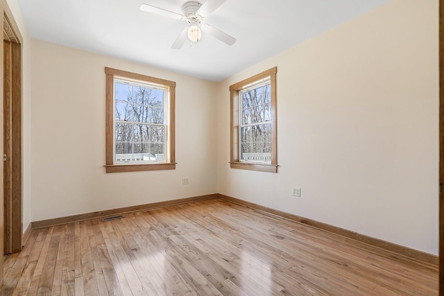 unfurnished bedroom with light wood-type flooring, visible vents, baseboards, and multiple windows