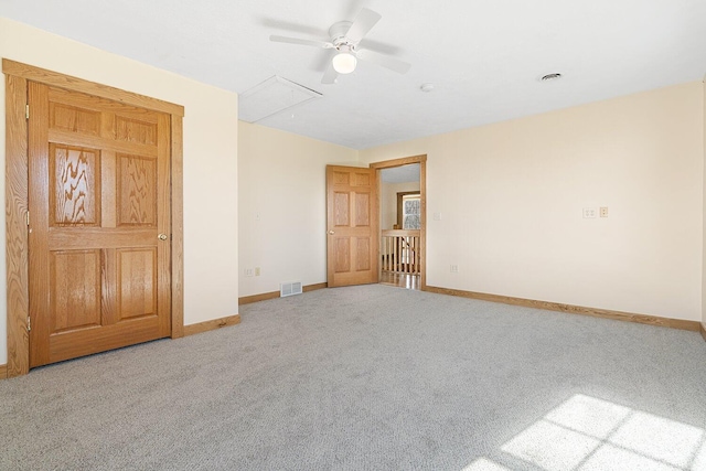 spare room featuring attic access, ceiling fan, baseboards, carpet flooring, and visible vents