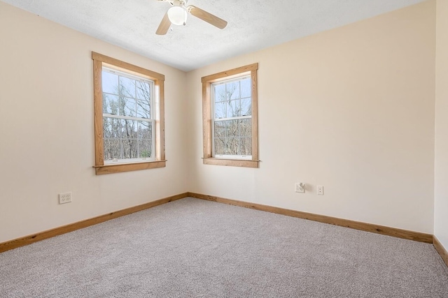 carpeted empty room with a textured ceiling, baseboards, and ceiling fan