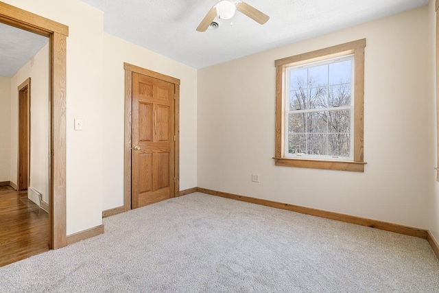 unfurnished bedroom with baseboards, a ceiling fan, and carpet