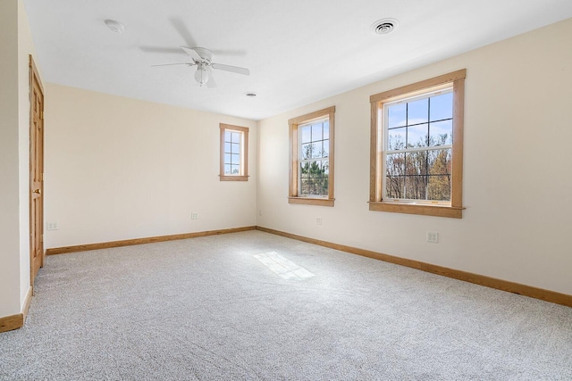 empty room with baseboards, visible vents, and carpet flooring