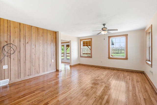 interior space featuring light wood-type flooring, visible vents, a ceiling fan, and plenty of natural light