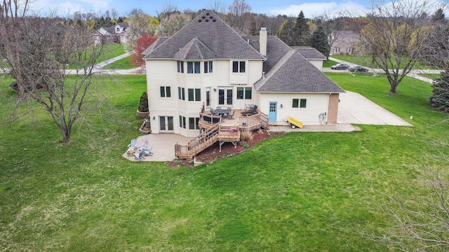 9037 Yorkshire Dr, Saline, MI 48176 - back of property with a chimney, a wooden deck, a patio area, a shingled roof, and a yard