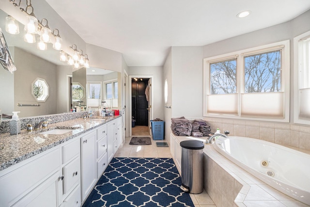 9037 Yorkshire Dr, Saline, MI 48176 - bathroom featuring a tub with jets, tile patterned floors, a sink, and double vanity