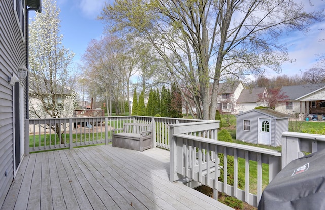 wooden deck with a lawn, a residential view, an outbuilding, and a storage unit