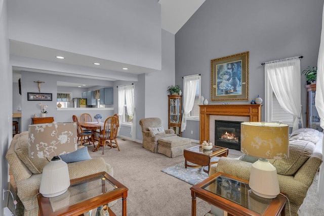 carpeted living area featuring recessed lighting, high vaulted ceiling, baseboards, and a tile fireplace