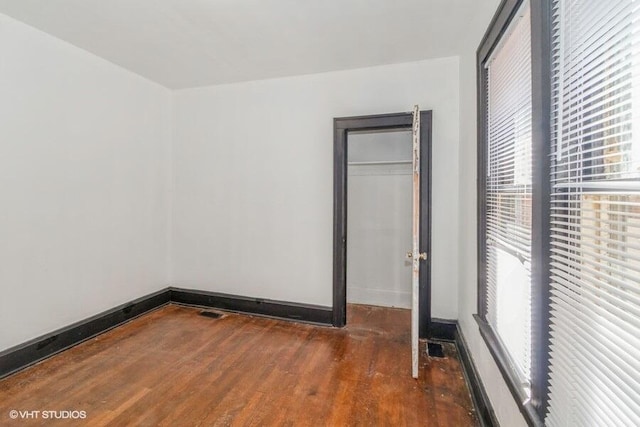 unfurnished bedroom with baseboards and wood finished floors