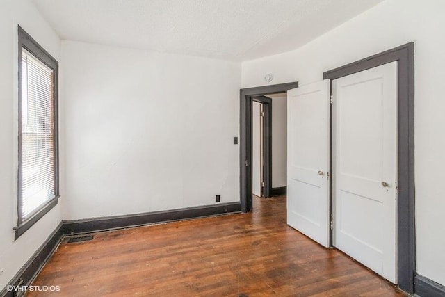 interior space with wood finished floors, visible vents, and baseboards