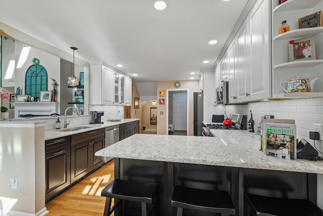 6240 Northridge Hills Dr, Brighton, MI 48116 - kitchen with a sink, stainless steel appliances, a peninsula, open shelves, and tasteful backsplash
