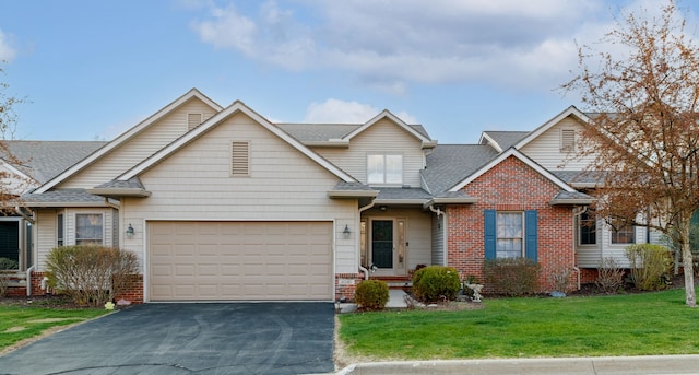 6240 Northridge Hills Dr, Brighton, MI 48116 - traditional home featuring asphalt driveway, brick siding, a front yard, a shingled roof, and an attached garage
