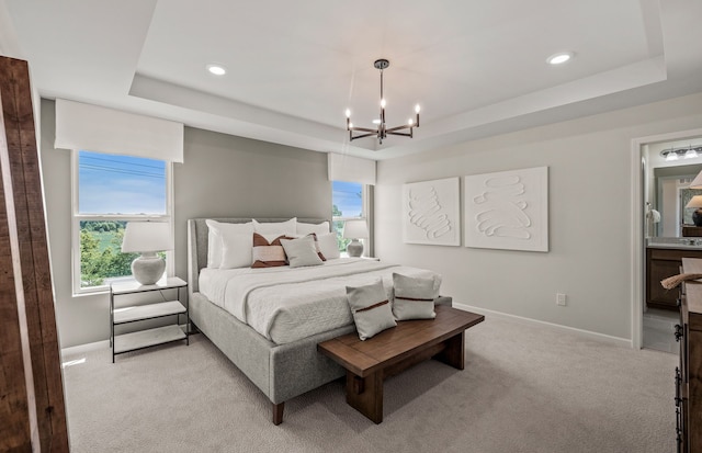 bedroom with light carpet, baseboards, a raised ceiling, and multiple windows