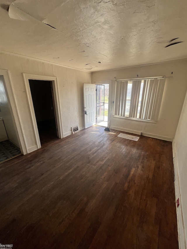 1048 Tremont Ave, Flint, MI 48505 - unfurnished living room with dark wood-type flooring and baseboards