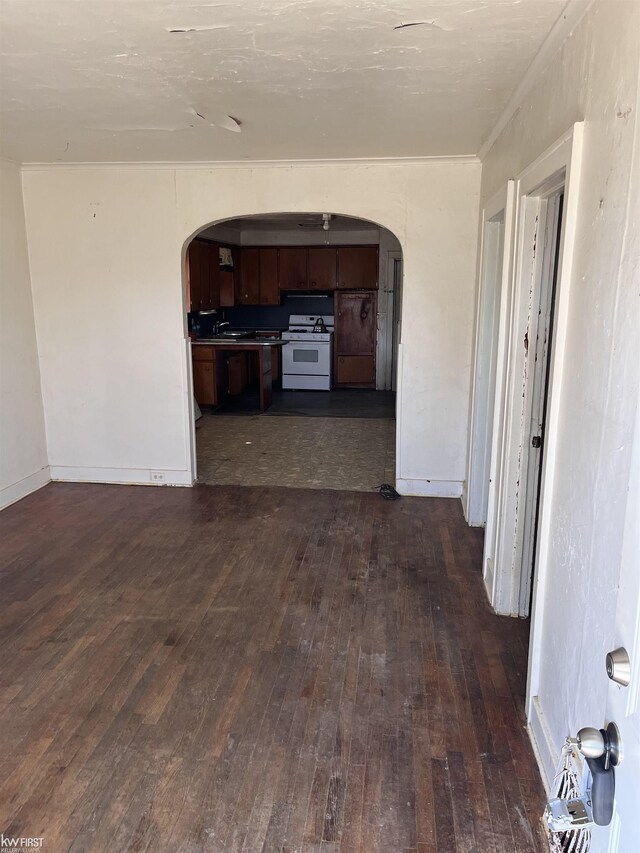1048 Tremont Ave, Flint, MI 48505 - spare room with arched walkways, dark wood-type flooring, baseboards, and a sink