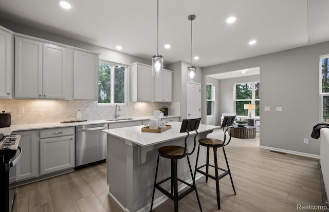 3058 Sheffield Cir, Clarkston, MI 48346 - kitchen featuring dishwasher, range, light wood-style floors, tasteful backsplash, and light countertops