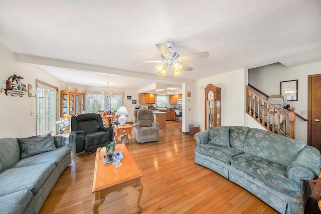 10500 Woodland Dr, Jerome, MI 49249 - living room featuring light wood finished floors and ceiling fan with notable chandelier