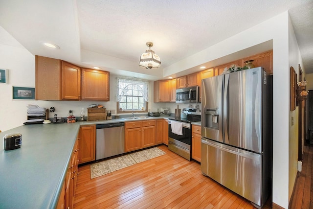 10500 Woodland Dr, Jerome, MI 49249 - kitchen with a sink, recessed lighting, light wood-style floors, decorative light fixtures, and appliances with stainless steel finishes