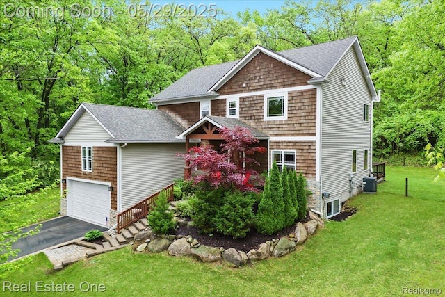 9327 Van Antwerp Rd, Brighton, MI 48116 - view of front of home with cooling unit, a front yard, driveway, roof with shingles, and an attached garage
