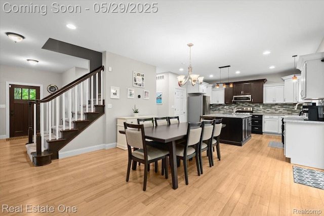9327 Van Antwerp Rd, Brighton, MI 48116 - dining space featuring light wood-style flooring, recessed lighting, stairs, a chandelier, and baseboards