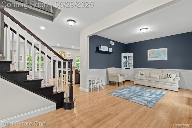 9327 Van Antwerp Rd, Brighton, MI 48116 - living room featuring a wainscoted wall, wood finished floors, stairway, and recessed lighting
