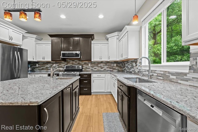 9327 Van Antwerp Rd, Brighton, MI 48116 - kitchen with appliances with stainless steel finishes, a sink, white cabinetry, pendant lighting, and decorative backsplash