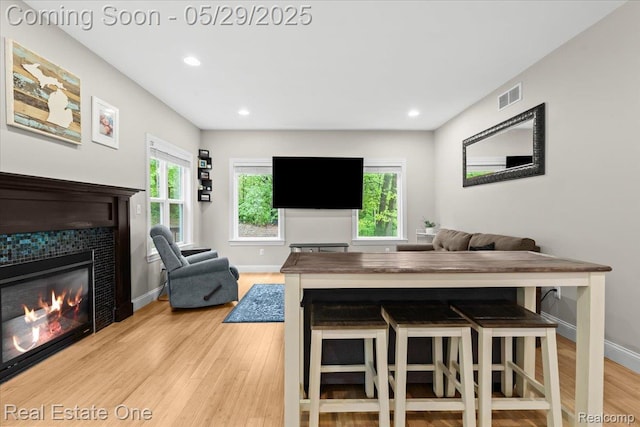 9327 Van Antwerp Rd, Brighton, MI 48116 - dining space with light wood-style floors, a fireplace, baseboards, and recessed lighting