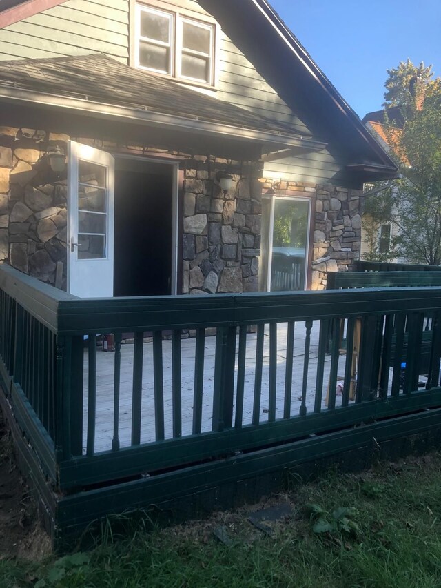 view of home's exterior featuring stone siding and a wooden deck
