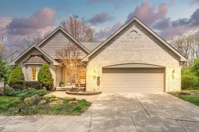 70 Chestnut Ct, Chelsea, MI 48118 - view of front of property with driveway, brick siding, and a garage