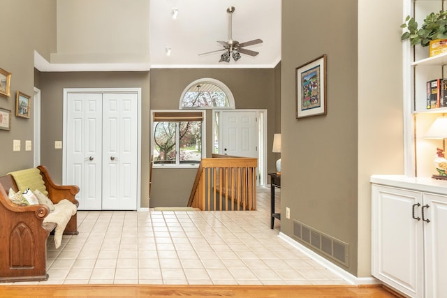 70 Chestnut Ct, Chelsea, MI 48118 - foyer with baseboards, visible vents, a ceiling fan, light tile patterned flooring, and high vaulted ceiling