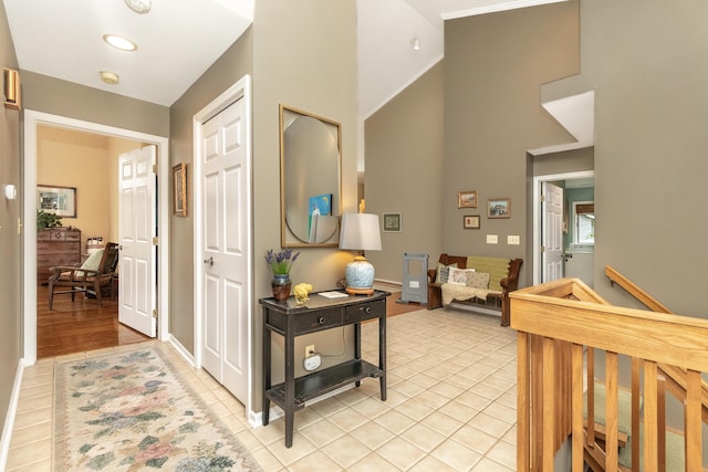 70 Chestnut Ct, Chelsea, MI 48118 - hallway featuring a high ceiling, light tile patterned flooring, and baseboards