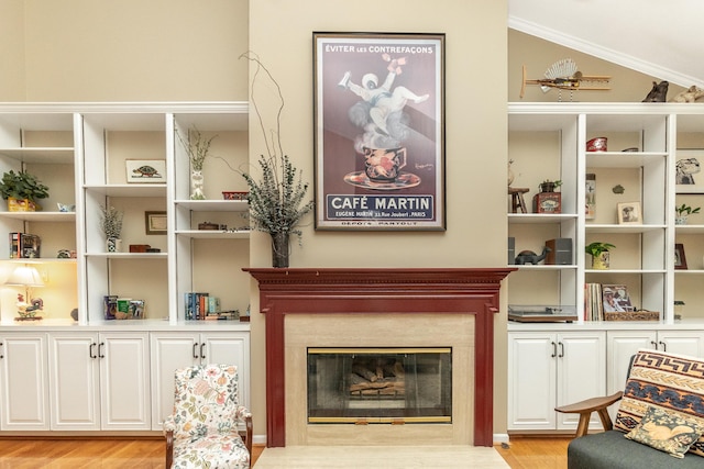 70 Chestnut Ct, Chelsea, MI 48118 - living area featuring lofted ceiling, a premium fireplace, light wood-type flooring, and crown molding