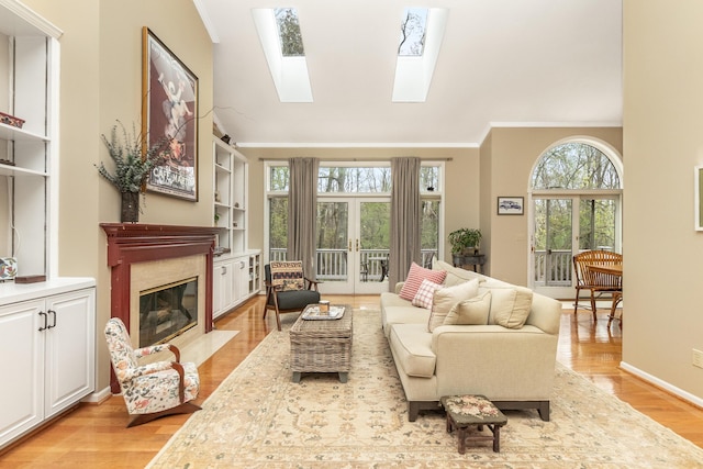 70 Chestnut Ct, Chelsea, MI 48118 - living room featuring a high end fireplace, light wood-type flooring, ornamental molding, and plenty of natural light