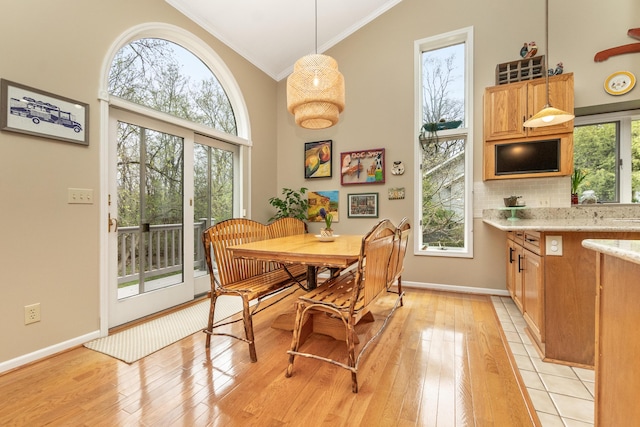 70 Chestnut Ct, Chelsea, MI 48118 - dining room with baseboards, high vaulted ceiling, light wood-style flooring, and crown molding