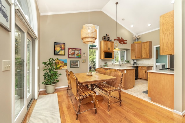 70 Chestnut Ct, Chelsea, MI 48118 - dining area with light wood-style flooring, crown molding, high vaulted ceiling, and baseboards