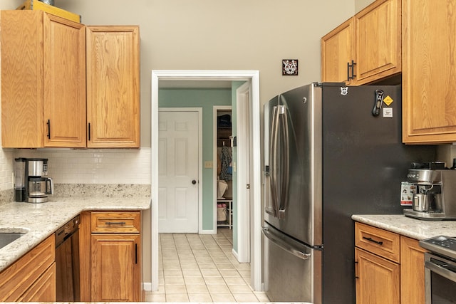 70 Chestnut Ct, Chelsea, MI 48118 - kitchen with tasteful backsplash, light stone countertops, light tile patterned floors, appliances with stainless steel finishes, and baseboards