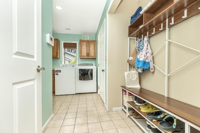 70 Chestnut Ct, Chelsea, MI 48118 - clothes washing area with light tile patterned floors, washing machine and dryer, visible vents, recessed lighting, and cabinet space