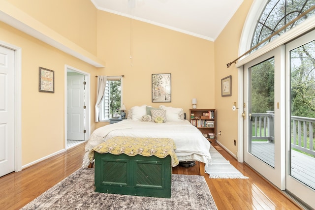 70 Chestnut Ct, Chelsea, MI 48118 - bedroom featuring crown molding, access to exterior, high vaulted ceiling, and wood finished floors