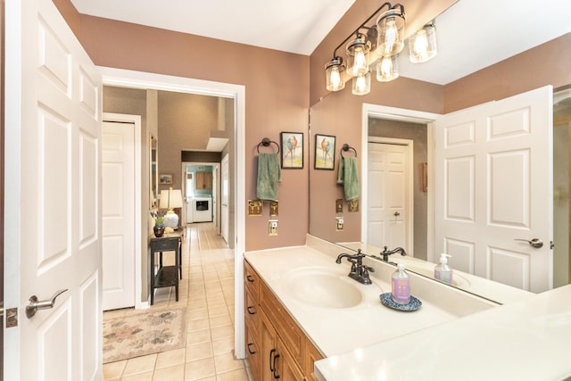 70 Chestnut Ct, Chelsea, MI 48118 - bathroom featuring washer / clothes dryer, tile patterned flooring, and vanity