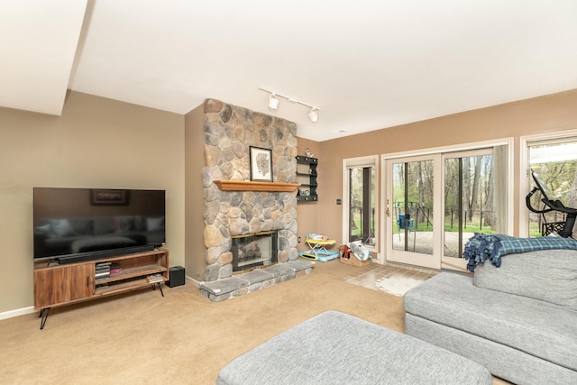 70 Chestnut Ct, Chelsea, MI 48118 - living area with track lighting, a stone fireplace, carpet, and baseboards