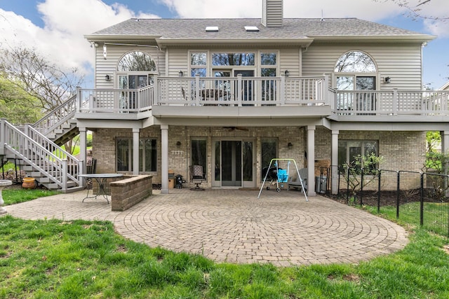 70 Chestnut Ct, Chelsea, MI 48118 - back of property featuring brick siding, fence, stairway, and a patio area