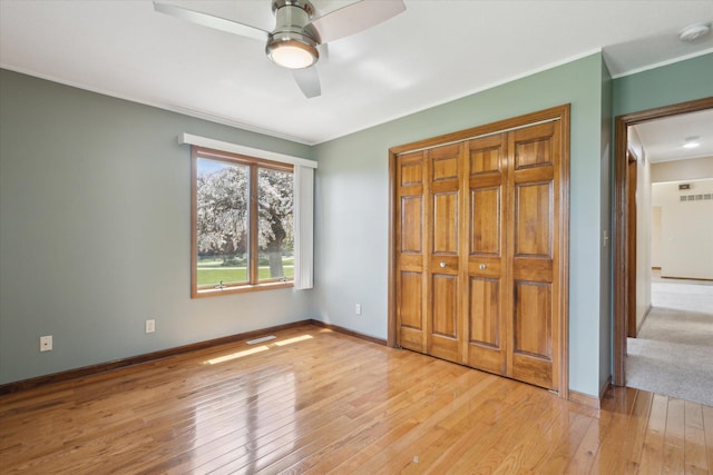 6030 Paw Paw Lake Rd, Coloma, MI 49038 - unfurnished bedroom featuring light wood-style floors, ornamental molding, a closet, a ceiling fan, and baseboards