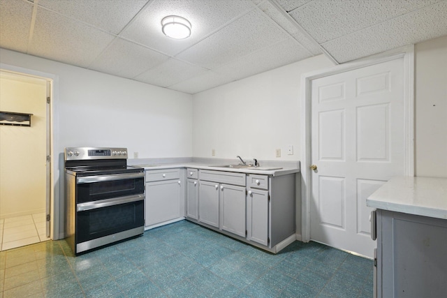 6030 Paw Paw Lake Rd, Coloma, MI 49038 - kitchen featuring range with two ovens, a drop ceiling, a sink, gray cabinetry, and light countertops