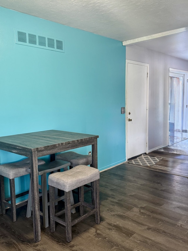 dining area featuring visible vents, baseboards, and wood finished floors