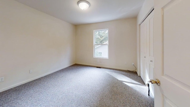 unfurnished bedroom with carpet floors, a closet, and baseboards