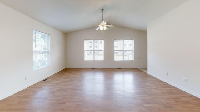empty room featuring wood finished floors, ceiling fan, and a healthy amount of sunlight