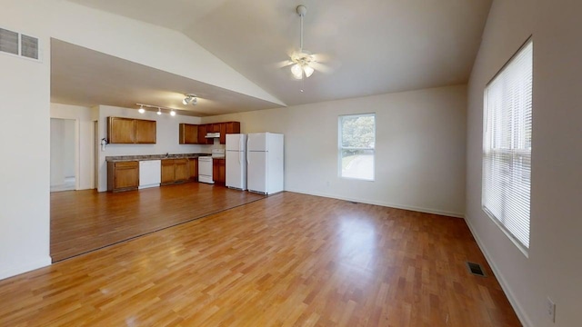 unfurnished living room with ceiling fan, vaulted ceiling, wood finished floors, and visible vents