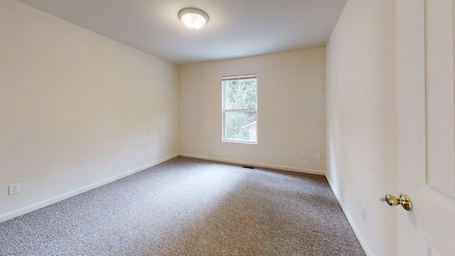 empty room featuring carpet, visible vents, and baseboards