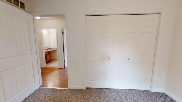 unfurnished bedroom featuring baseboards, visible vents, a closet, and carpet flooring