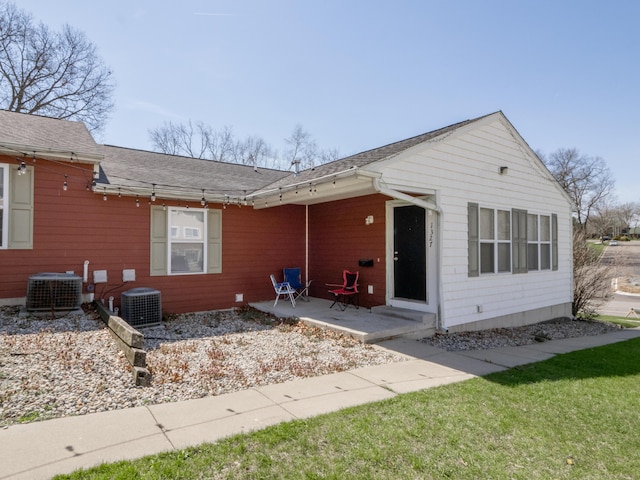 rear view of property featuring a yard, a patio area, and central AC unit