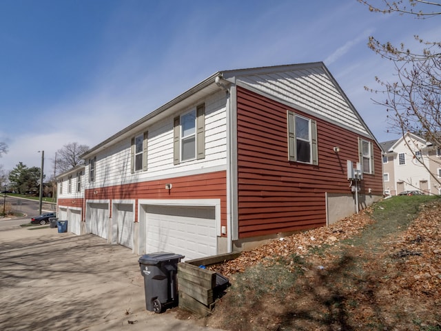 view of side of property featuring an attached garage and driveway